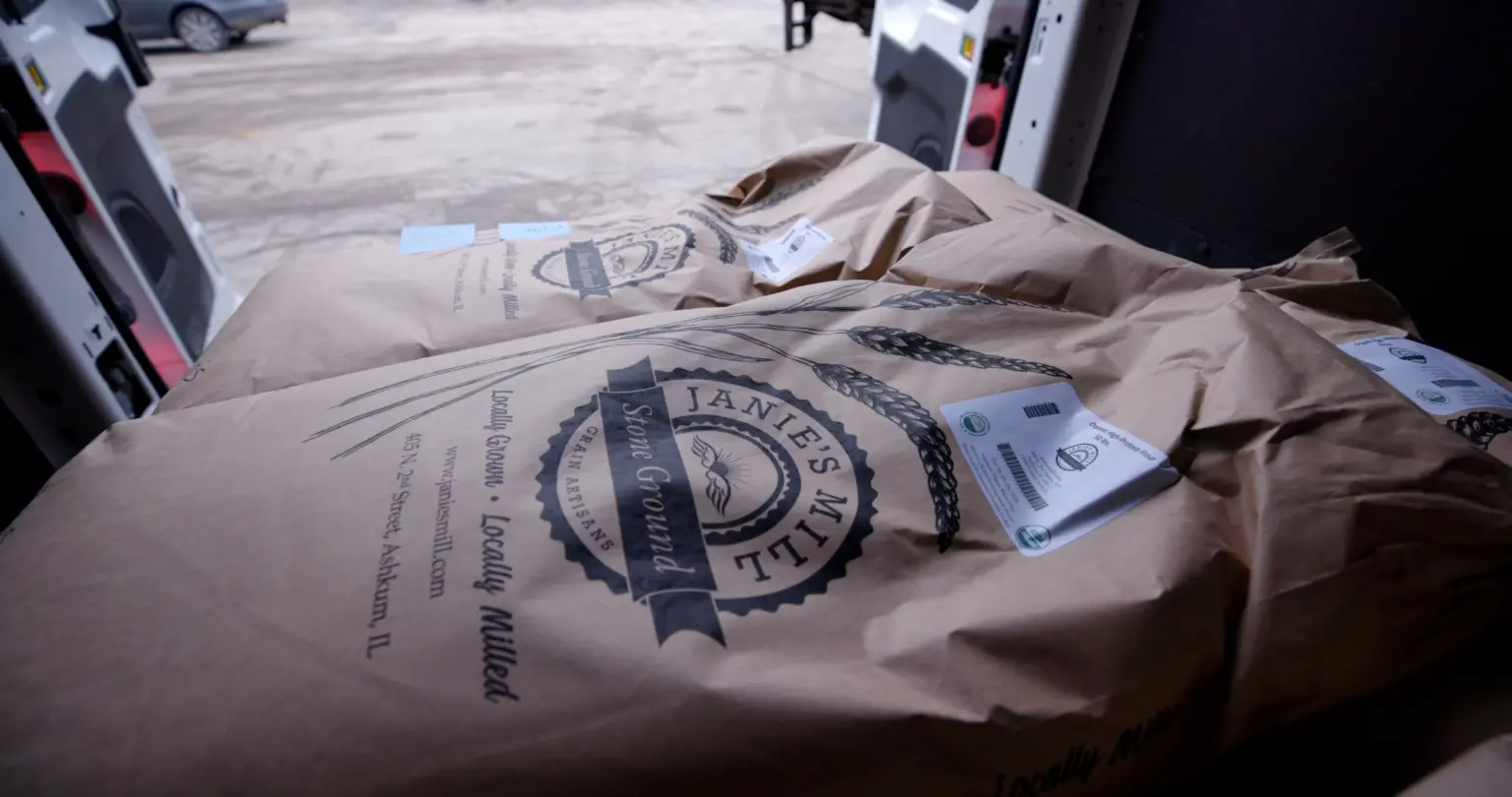 Organic certified grain bags with labels at warehouse loading dock